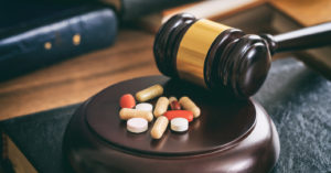 Gavel next to drugs on a desk