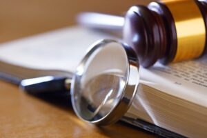 A gavel, magnifying glass, and book being used in a federal investigation.
