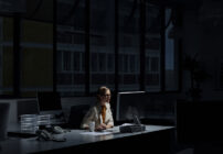 A businesswoman in an office sits at a computer, learning about what happens when a federal and state investigation overlaps.