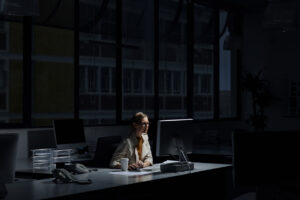 A businesswoman in an office sits at a computer, learning about what happens when a federal and state investigation overlaps.